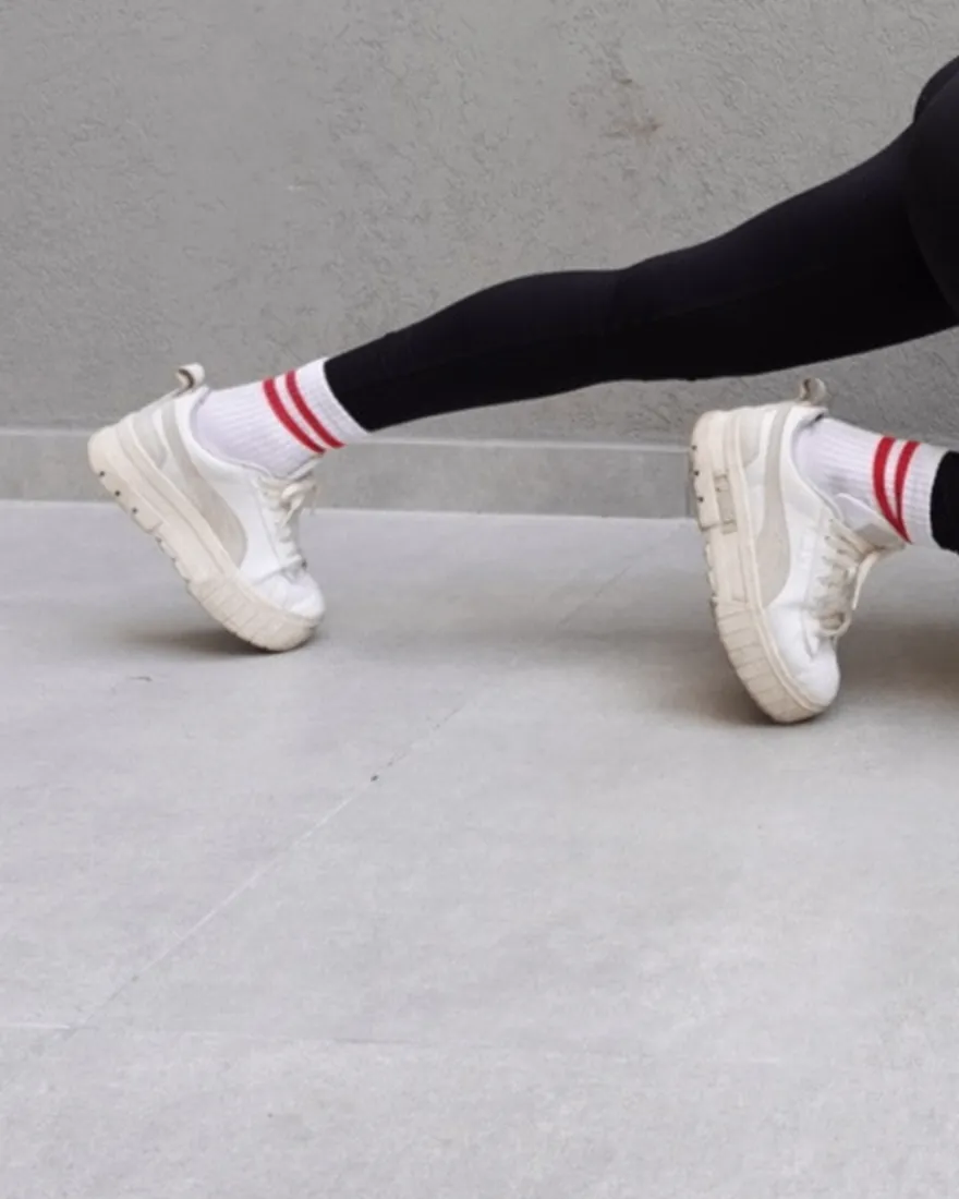 Detalle de las zapatillas blancas y medias a rayas de Andre durante un ejercicio